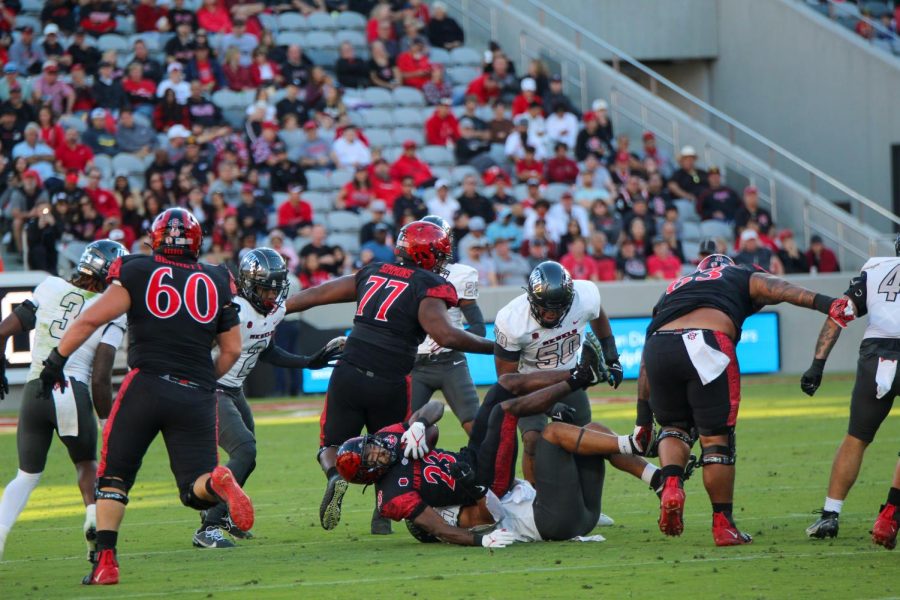 Holding the ball to his chest, junior running back Kenan Christon falls to the ground after a tackle at the UNLV football game on Saturday, Nov. 5, 2022.