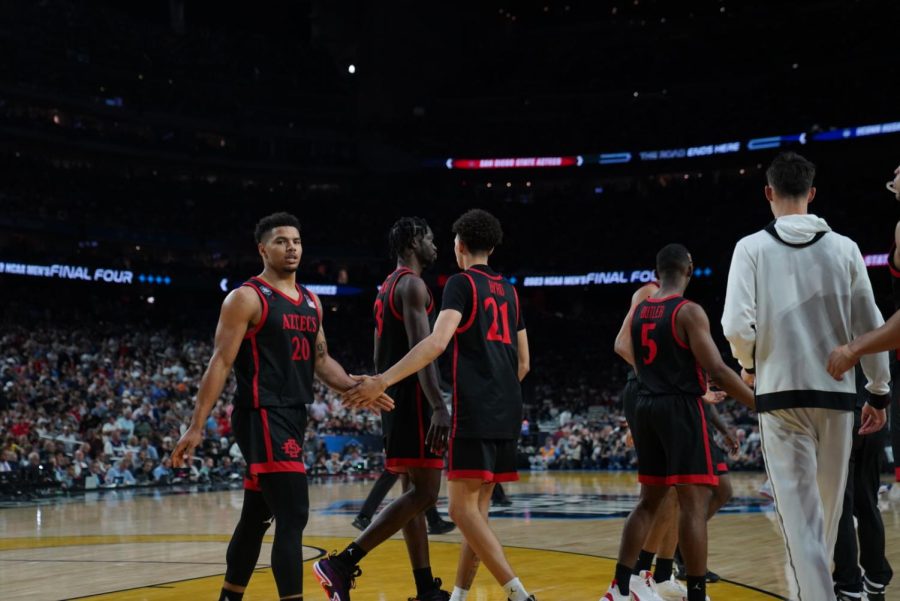 SDSU senior Matt Bradley walks towards the Aztec bench while high-fiving freshman Miles Byrd during SDSU's 76-59 loss to UConn in the National Championship on Monday, April 4.