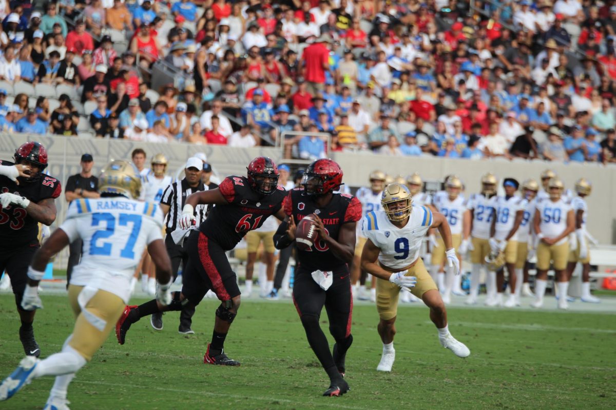 San Diego State quarterback Jalen Mayden looks downfield as he faces pressure from two UCLA defenders during Aztecs 35-10 loss on Saturday Sep.9th at Snapdragon Stadium. Mayden had 196 yards passing along with a touchdown and three interceptions. (Isabella Biunno) 