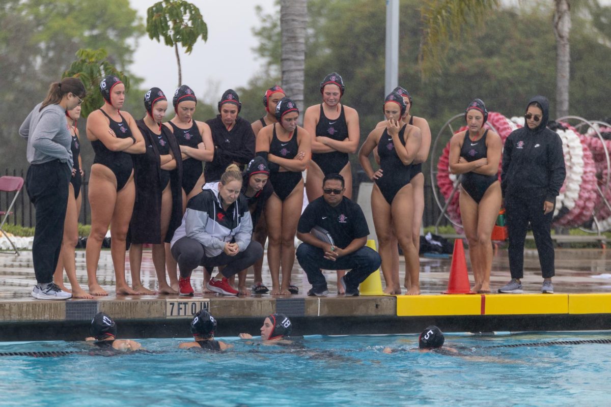 Head coach Dana Ochsner and assistant coach Randy Galza debrief with the team during the end of the second period against Stanford last season at the Aztec Aquaplex.
