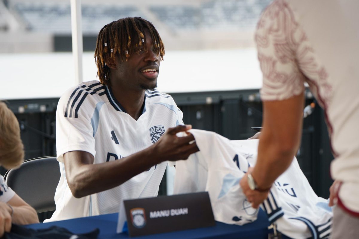 Manu Duah hands the jersey back to the fan after he signs it at the San Diego FC kickoff party at Snapdragon Stadium on Feb. 16. 