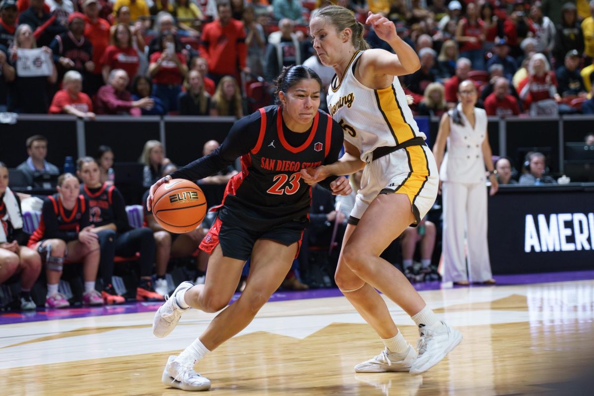 San Diego State forward Kim Villalobos drives past Wyoming player Tess Barnes into the paint during the Mountain West Championship in Las Vegas at the Thomas & Mack Center on March 12, 2025.