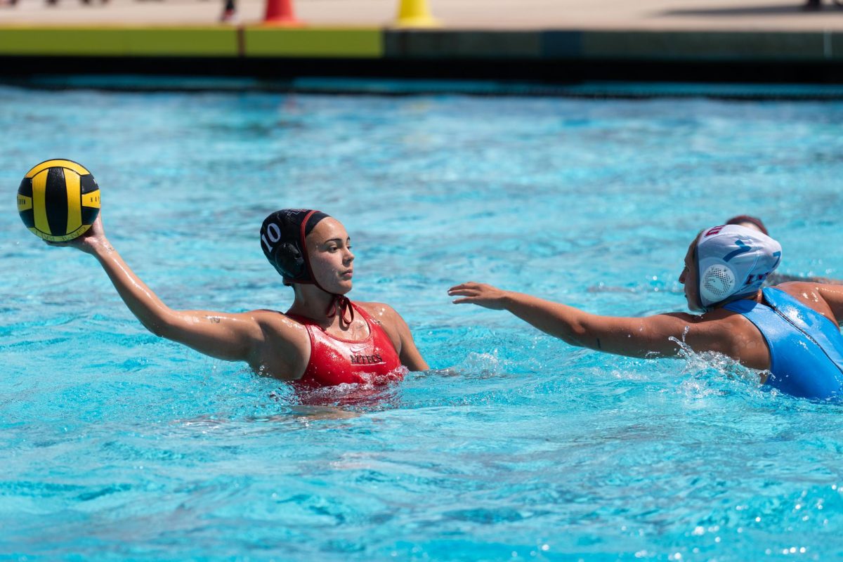 San Diego State defender Luna Sarmiento attempts to pass over an incoming defender in an 11-17 loss against Loyola Marymount at the Aztec Aquaplex on April 12, 2025. 